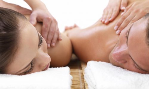 Close-up of man and woman receiving shoulder massage